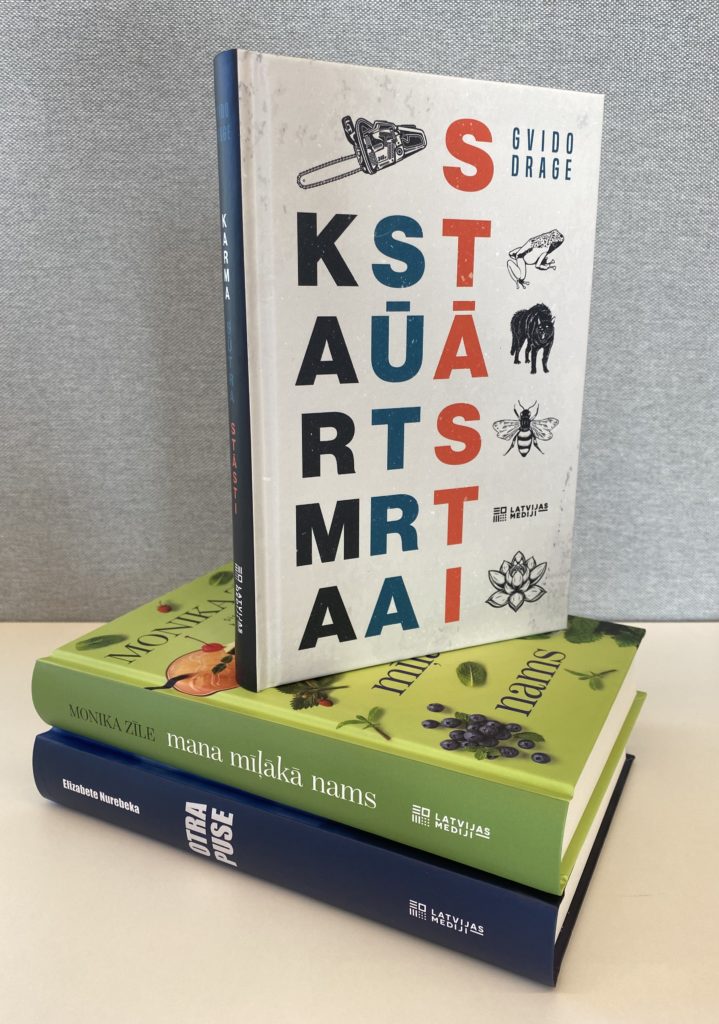 divas grāmatas, kas sakrautas viena uz otras. Augšējai grāmatai ir balts mugurkauls ar tekstu un dažādiem maziem attēliem, piemēram, atslēgu, kukaini un velosipēdu. Apakšējai grāmatai ir zaļš mugurkauls ar tekstu.