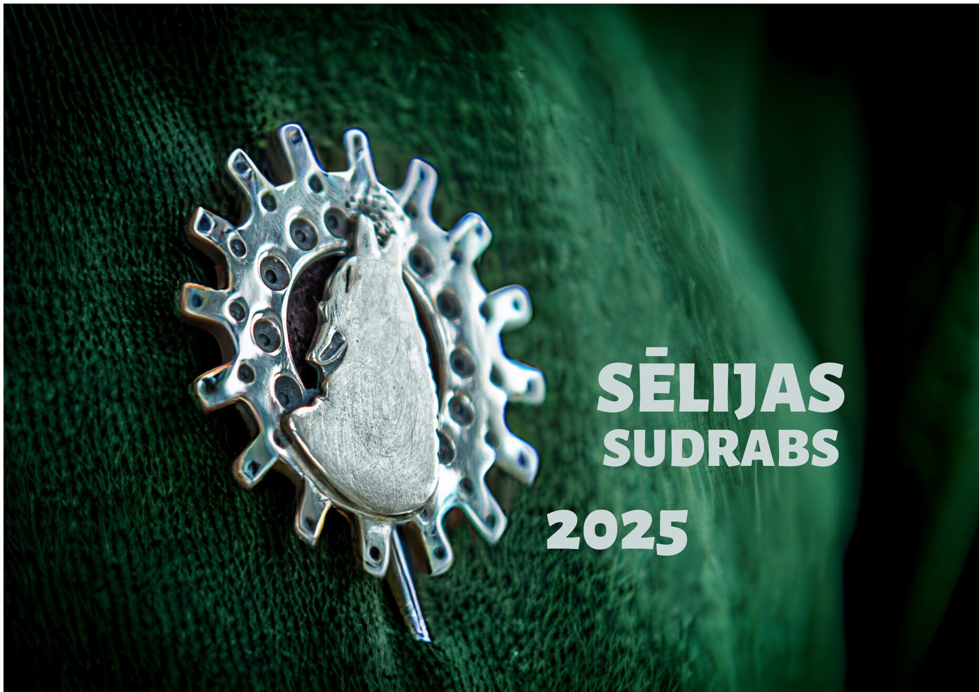 Sudraba piespraude ar vilka galvas siluetu un ratu zobrata formu, piesprausta pie zaļas auduma virsmas. Labajā pusē ir uzraksts: "SĒLIJAS SUDRABS 2025"