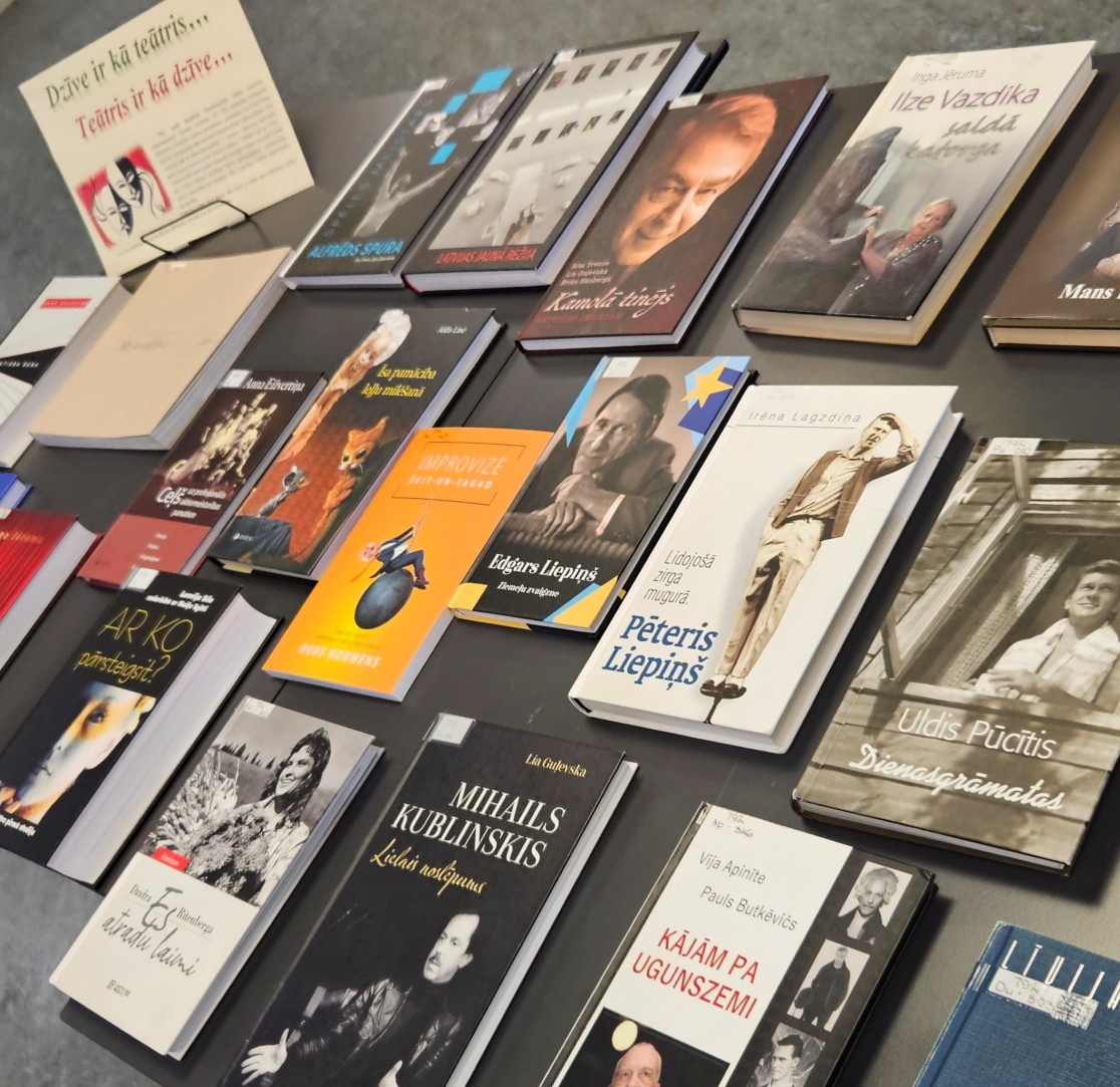 Galds ar izkārtotām grāmatām, galvenokārt par teātri un aktieriem. Redzamas biogrāfijas un atmiņu grāmatas, piemēram, par Pēteri Liepiņu, Uldi Pucīti un Mihailu Kublinski. Tā ir teātrim veltīta grāmatu izstāde.